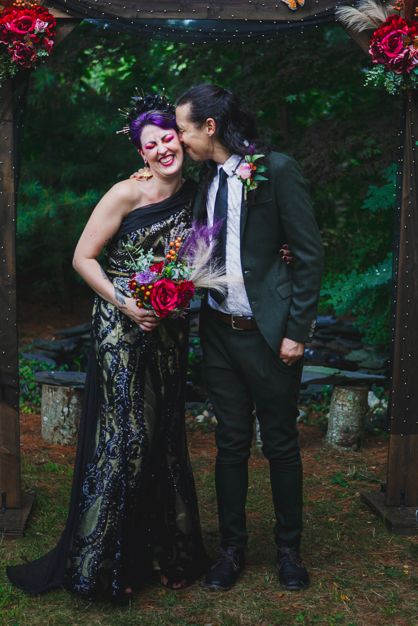 Non-binary wedding couple posing and laughing together at altar on wedding day