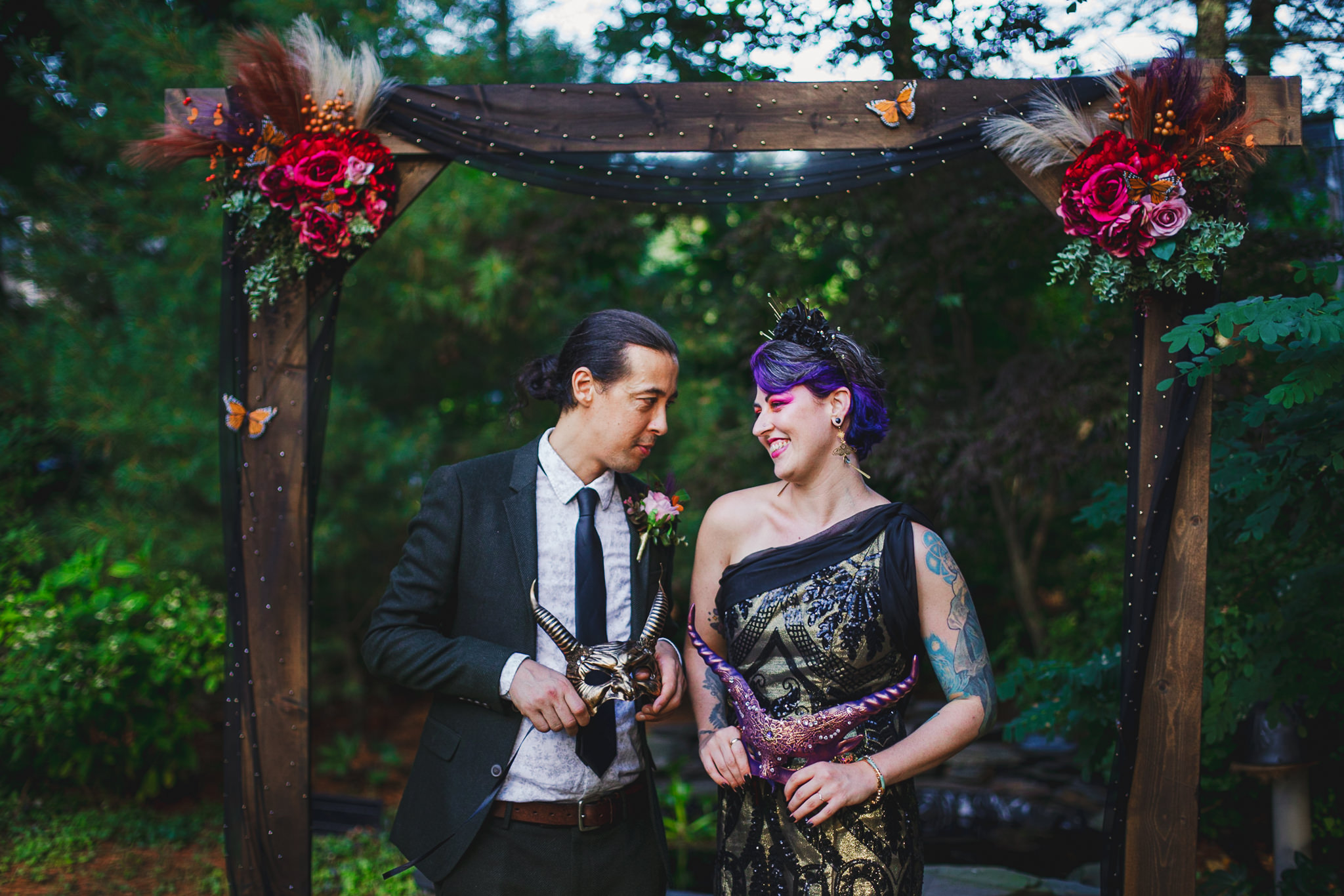 Non-binary wedding couple posing and laughing together at altar on wedding day