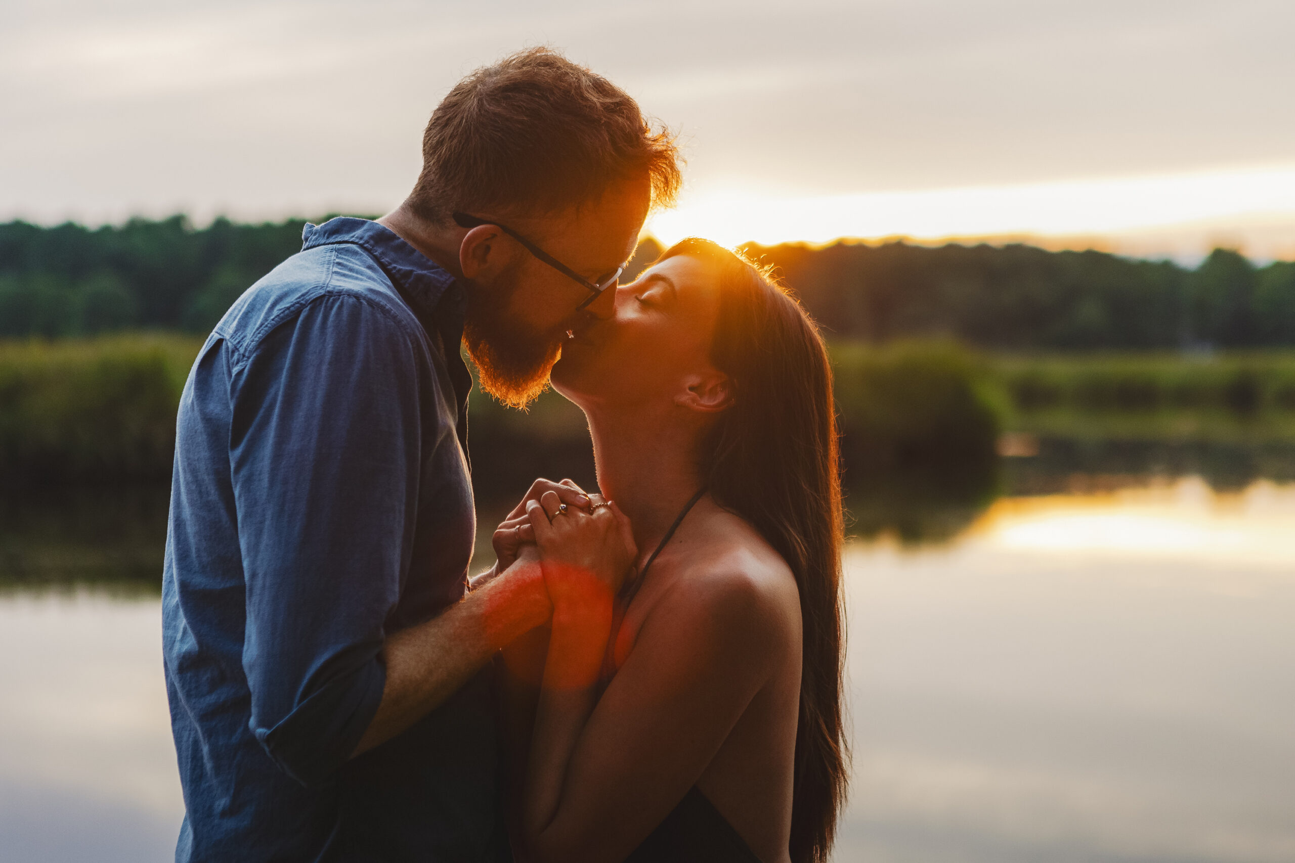 Couple kissing at sunset by North River in Marshfield, MA during engagement photoshoot