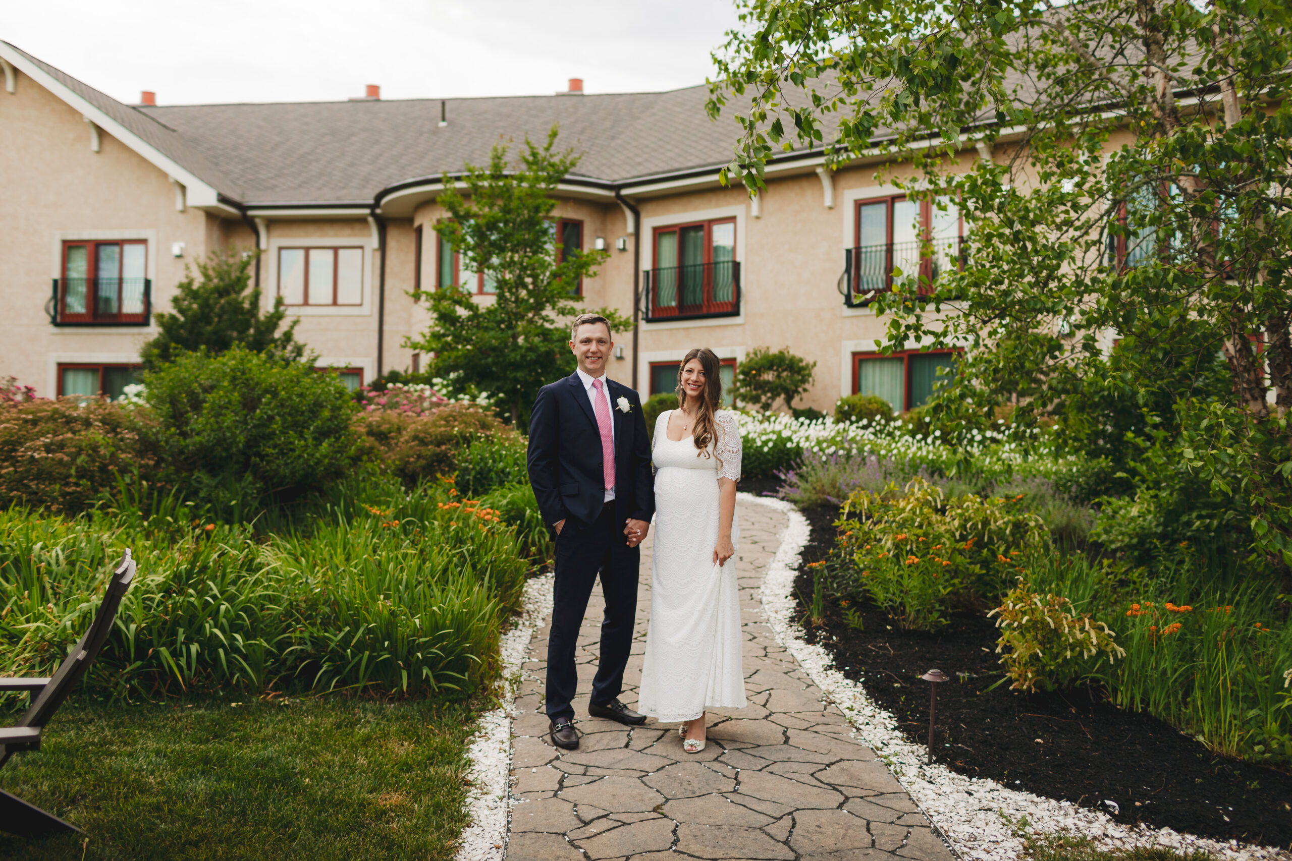 Bride and Groom on stone path in garden bar at Mirbeau Inn & Spa at the Pinehills in Plymouth, MA